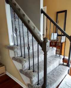 A newly installed grey carpet on a staircase with decorative metal balusters by GC&D Flooring in Allentown, PA.
