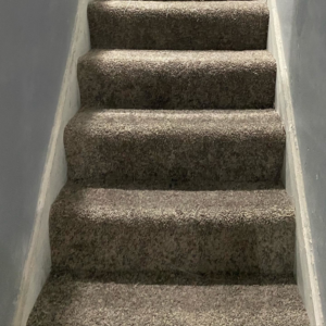 A close-up view of a newly carpeted staircase, showcasing quality installation by HK Carpet Doctors in Sterling Heights, MI