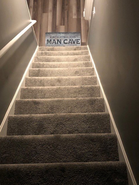 A newly installed gray carpet on a staircase leading to a basement, completed by Metro Flooring Company in Jeffersontown, KY