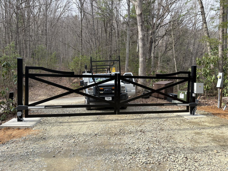 A newly installed black automatic gate with a Gilliam Services LLC work truck in Johnson City, TN.