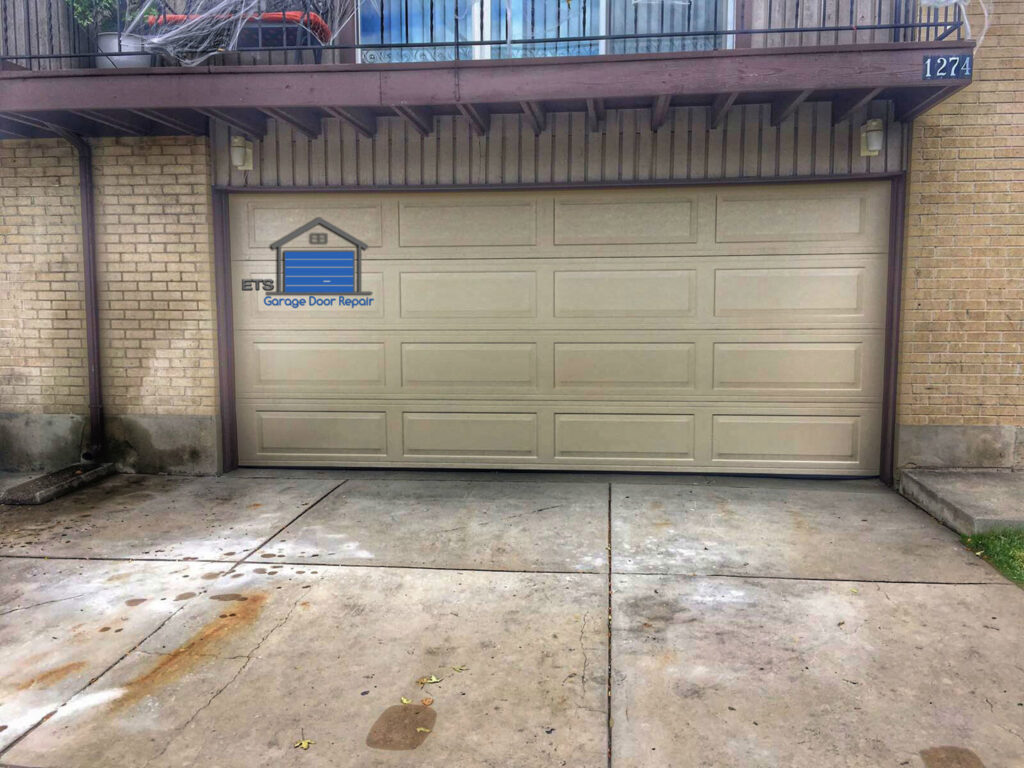 A newly installed beige panel garage door on a brick house by ETS - Garage Door & Electric Gate Repair Of Bellevue, WA.