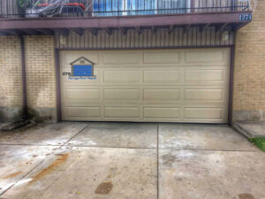 A newly installed beige panel garage door on a brick house by ETS - Garage Door & Electric Gate Repair Of Bellevue, WA.