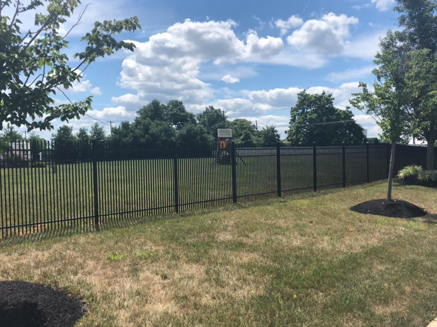 A newly installed black aluminum fence in a landscaped area by Mercer Fence Company in Hamilton Township, NJ.