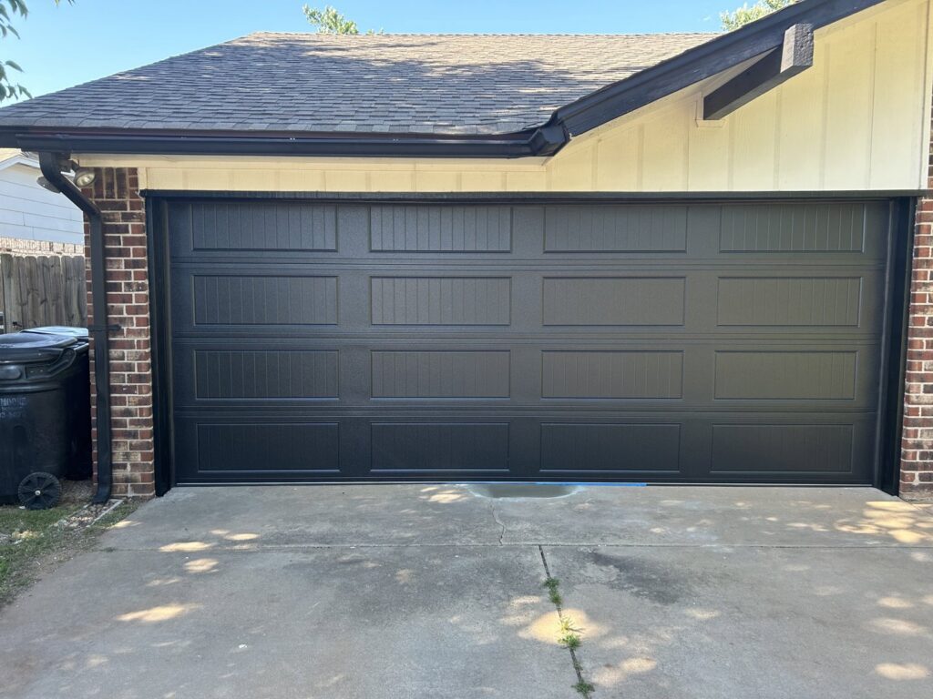 A newly installed black garage door on a residential house by 405 Garage Pros in Edmond, OK.