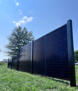 A newly installed black solar fence line extending across a grassy area by Sol Fence LLC in Evansville, IN.