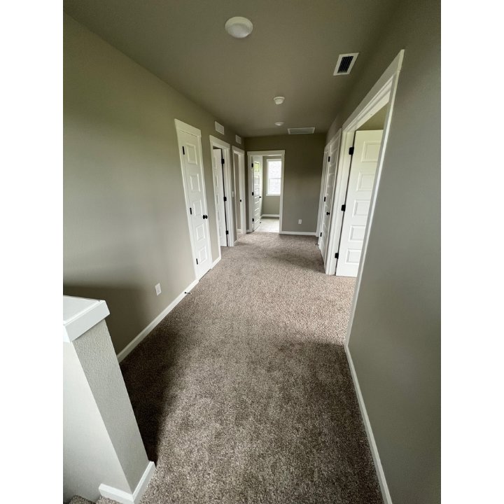 A newly installed brown carpet in a residential hallway by Pg Long Floorcovering LLC in Portland, OR.