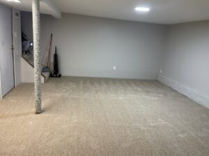 A newly installed light beige carpet in a finished basement room by JJS Flooring & Decorating Co Inc in Saint Louis, MO.