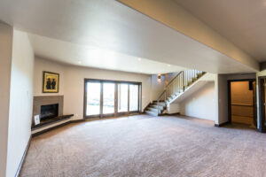 A spacious living room featuring newly installed light-colored carpet by Floors & More Abbey Flooring in Great Falls, MT.