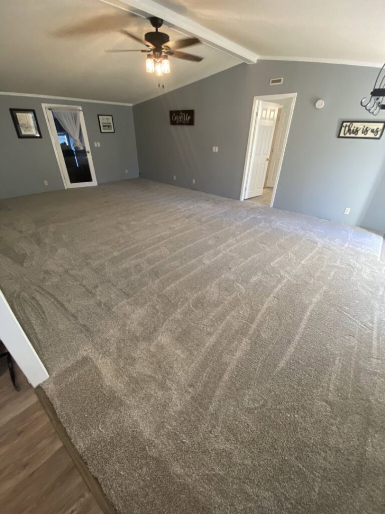 Newly installed gray carpet in a spacious living room by Legacy Flooring Co. in Murfreesboro, TN.