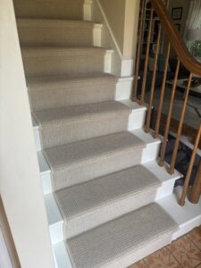 Newly installed light-colored carpet on a residential staircase by Lakefront Flooring in Erie, PA.