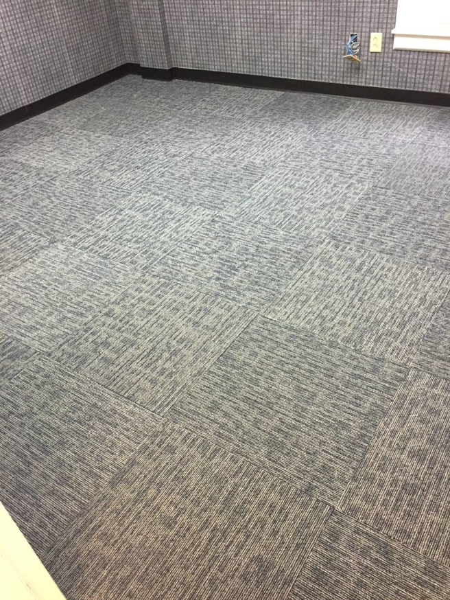 Newly installed grey carpet tiles in a room, showcasing a professional carpet contractor job by Tony Trujillo Flooring Sales & Installation in Franklin, TN.