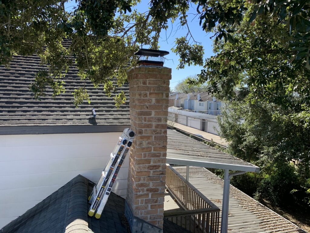 A newly installed concrete chimney crown on a brick chimney, indicating recent repair work by Lone Star Chimney in Houston, TX.