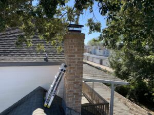 A newly installed concrete chimney crown on a brick chimney, indicating recent repair work by Lone Star Chimney in Houston, TX.