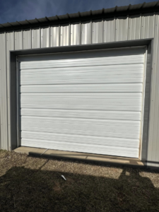 A newly installed white commercial garage door by Entry Garage Door in Shawnee, OK.