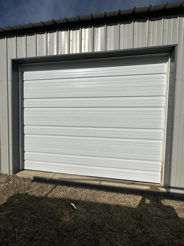 A newly installed white commercial garage door by Entry Garage Door in Shawnee, OK.