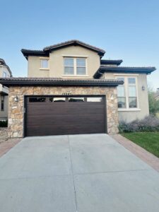 A residential home showcasing a newly installed dark brown garage door by PNG Garage Doors llc in Lakewood, CO.