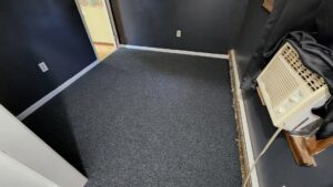 A newly installed dark grey carpet in a room, showcasing the quality work by Carpet Maven Flooring in Woodbridge, NJ.