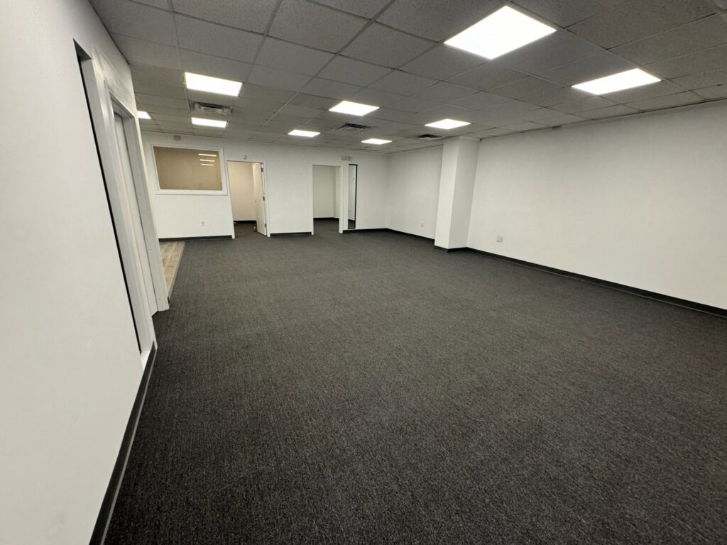 Newly installed dark grey carpet in a spacious commercial room by Global Flooring Enterprise in Miami, FL.