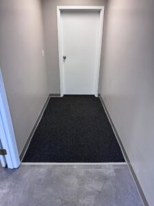 Newly installed dark grey carpet in a hallway by Mr. Flooring, a carpet contractor in St. Charles, MO.