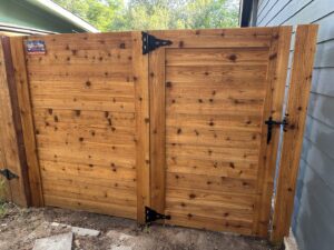 A newly installed double wood gate with stylish black hardware, completed by Stand Strong Fencing of East Austin, TX.
