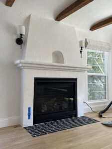 A newly installed modern fireplace insert with a black finish and tiled hearth by The Chimney Guy in Los Angeles, CA.