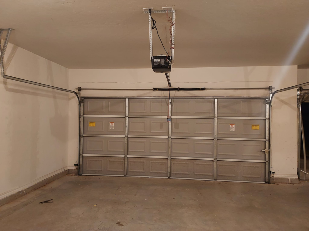 A newly installed garage door with an automatic opener system by Zee's Garage Doors in Oklahoma City, OK.