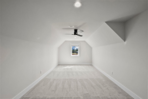 A bright attic room with newly installed gray carpet by Shop At Home Carpets in Bowling Green, KY.
