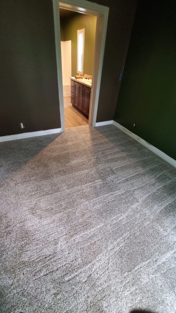 A newly installed gray carpet in an empty bedroom by Carpet Mart of Idaho Falls in Idaho Falls, ID.