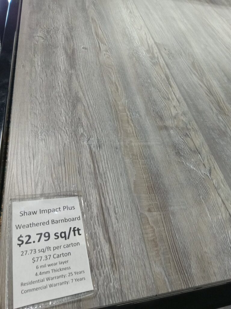 Newly installed gray carpet in a residential bedroom with teal walls by Wholesale Carpet of Sumter in Sumter, SC.