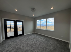 A spacious room featuring newly installed gray carpet by Flooring by Stix and Stonz in Butte, MT.