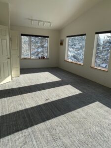 A spacious room featuring newly installed gray patterned carpet by Fairbanks Carpets Plus in Fairbanks, AK