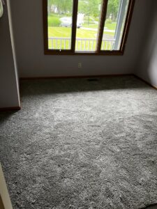 A room featuring newly installed gray carpet by Carpet Warehouse Lorain LLC in Lorain, OH.