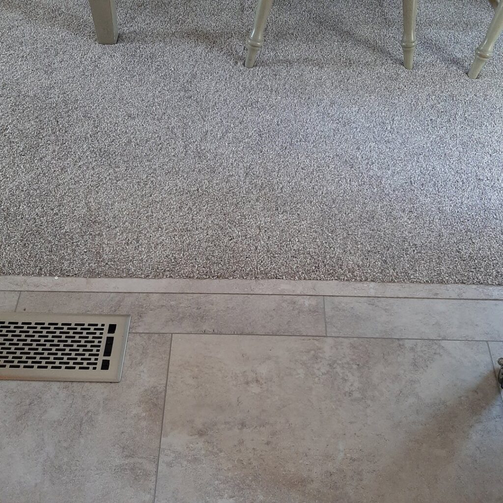 A newly installed gray carpet transitioning to tile flooring by Bush Flooring Center in Cincinnati, OH.