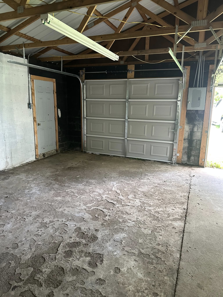 A newly installed gray sectional garage door inside a garage by Phelps Dock and Door in Cave City, KY.
