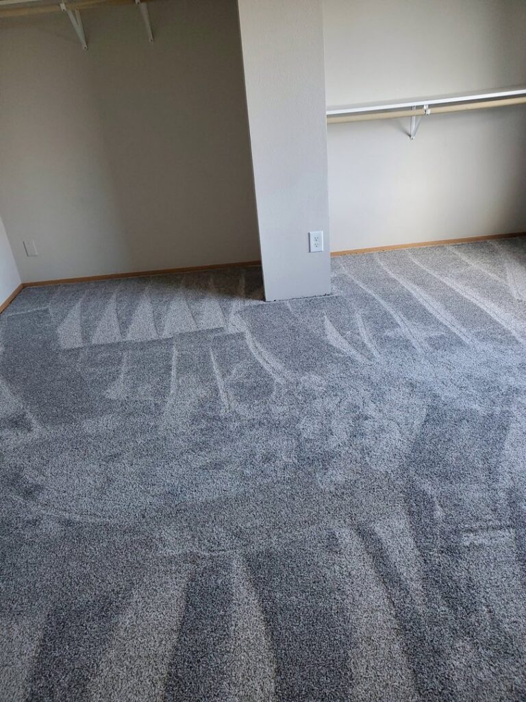 Newly installed grey carpet with vacuum lines in a bedroom by Columbia Flooring Group in Troutdale, OR