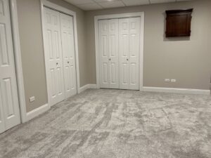 A room featuring newly installed light grey carpet by At Home Flooring in Naperville, IL.