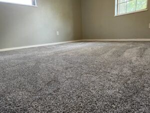 A bedroom with newly installed grey carpet by Carpet Depot Okc in Oklahoma City, OK.