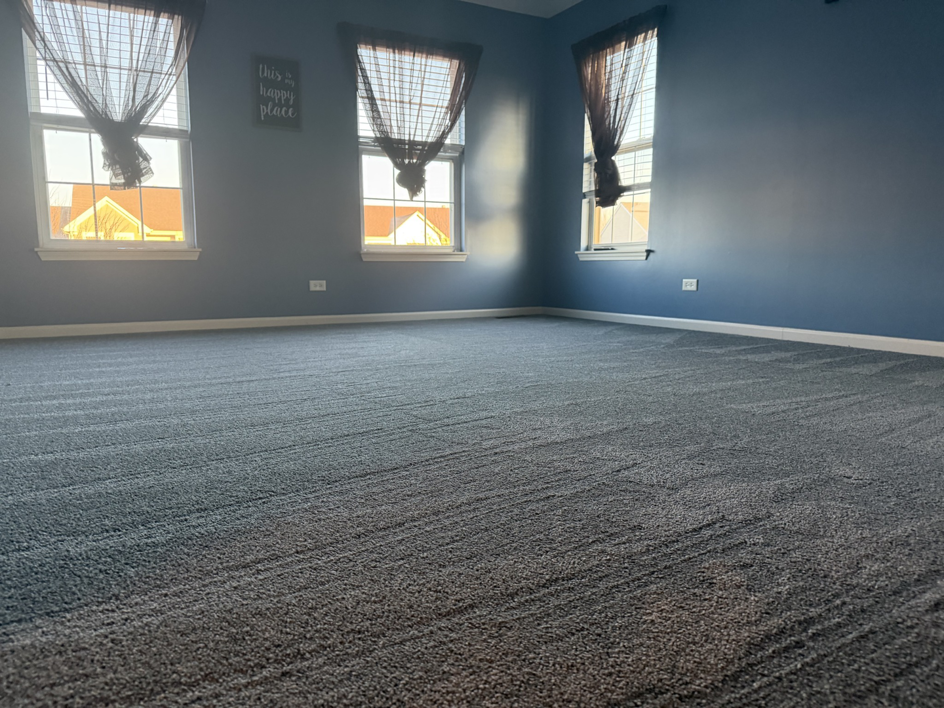 A spacious bedroom featuring newly installed grey carpet by Carpet Near Me, available in Services Available In.