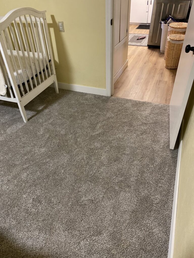 Newly installed grey carpet in a bedroom, showcasing a completed carpet contractor job by Idaho Floors in Meridian, ID.
