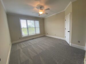 A bedroom featuring newly installed grey carpet by P&Q Flooring in Johns Creek, GA, showcasing quality workmanship.
