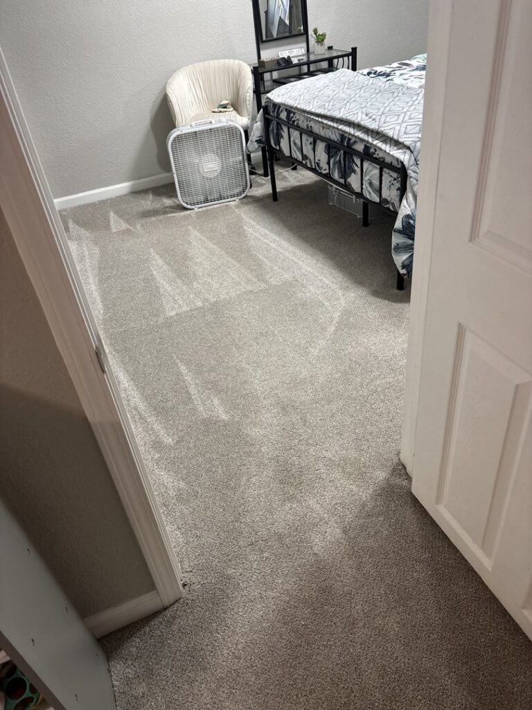 A newly installed grey carpet in a bedroom, showcasing quality work by Richie's Flooring in Whitestone, NY