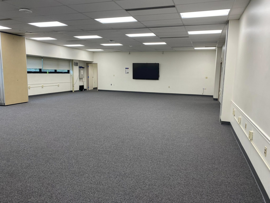A large room with newly installed grey carpet by Floor Perfection of Arkansas in Conway, AR