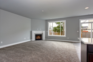 A newly installed grey carpet in a modern living room by Carpet One Topeka in Topeka, KS