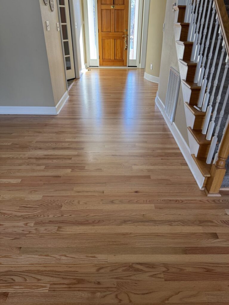 Newly installed hardwood flooring in a home entryway and hallway by Augusta Carpet Mart in Augusta, GA.