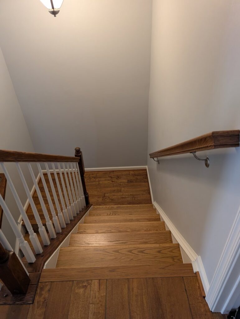 A view of newly installed hardwood flooring on a staircase, a service provided by Petersen's Carpet & Flooring in Frederick, MD