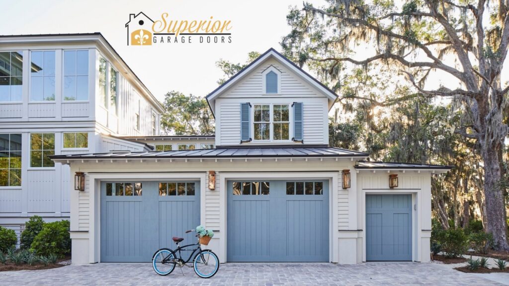 Newly installed light blue residential garage doors on a modern home by Superior Garage Door & Repairs in Lafayette, LA.