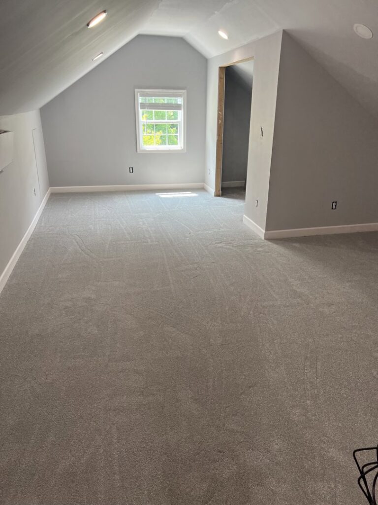 Newly installed light grey carpet in an attic room by Seaford Flooring in Seaford, DE.