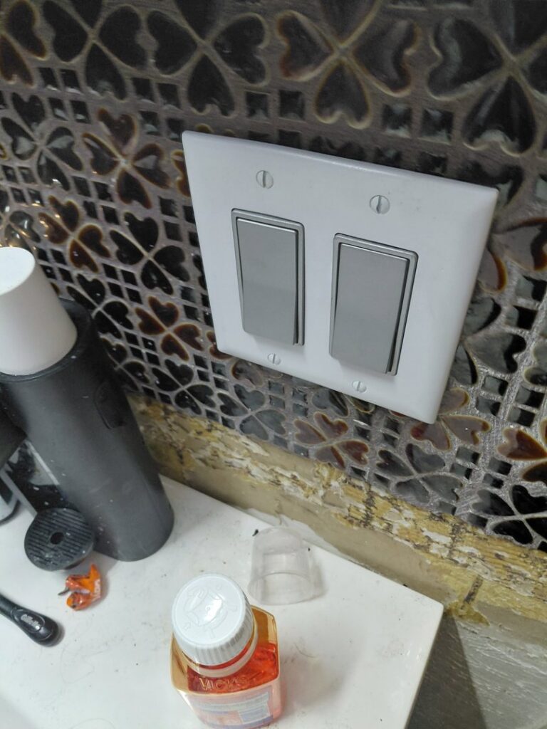 Newly installed light switches on a decorative tiled wall by LE Electric in Las Cruces, NM