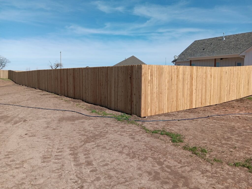 A newly installed long wood privacy fence by Veteran Fence Company LLC in Shawnee, OK.