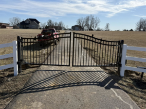 A newly installed black metal gate and white fence posts at a residential property by Henderson Fence in Culpeper, VA.
